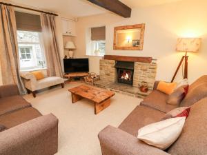 a living room with a couch and a fireplace at End Cottage in Skipton