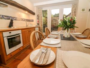 a kitchen and dining room with a table and chairs at End Cottage in Skipton