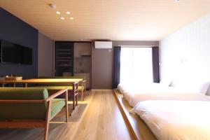 大阪市にある5 minutes 新大阪 9のベッド2台、テーブル、椅子が備わる客室です。