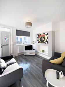 a living room with two couches and a tv at The Baltic Townhouses by Serviced Living Liverpool in Liverpool