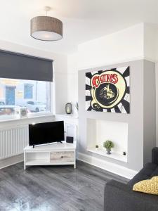 ein Wohnzimmer mit einem TV und einem Sofa in der Unterkunft The Baltic Townhouses by Serviced Living Liverpool in Liverpool