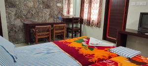 a bedroom with a bed with a colorful blanket at Hotel Temple View in Madurai