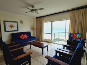 a living room with a blue couch and a table at Santana Holiday Resort in Margate