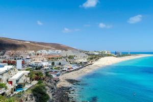 a view of a beach with buildings and the ocean at Casas Pedro & Agata in Morro del Jable