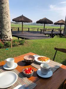 a wooden table with food and cups on top of it at Porto Fazenda Hotel in Alfenas