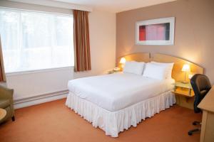 アシュフォードにあるHoliday Inn Ashford - North A20, an IHG Hotelの白いベッドと窓が備わるホテルルームです。
