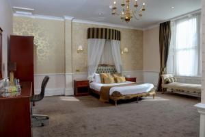 a bedroom with a bed and a chandelier at Burnley North Oaks Hotel and Leisure Club in Burnley