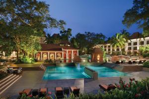 a resort with a pool and tables and chairs at Grand Hyatt Goa in Panaji