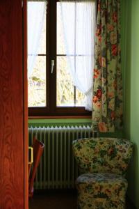 a room with a chair and a window and a radiator at Gasthaus Krone Märkt in Weil am Rhein