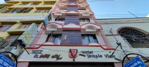 un grand bâtiment avec un panneau sur son côté dans l'établissement Hotel Temple View, à Madurai
