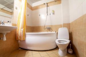 a bathroom with a tub and a toilet and a sink at Hotel Nevskiy 98 in Saint Petersburg