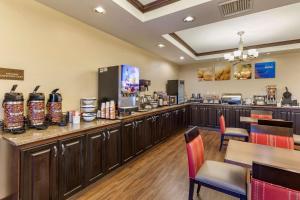 a restaurant with a bar with tables and chairs at Comfort Inn & Suites Russellville I-40 in Russellville