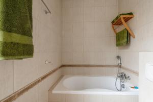 a bathroom with a tub and a green towel at Gostynin Garden Apartment II in Gostynin +19 photos