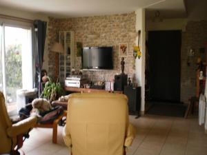 sala de estar con silla amarilla y TV en les Mésanges bleues, en Saint-Jouan-de-lʼIsle
