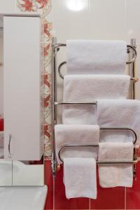 a rack of towels in a bathroom with a mirror at Versal Hotel in Maykop
