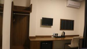 Habitación con escritorio y TV en la pared. en My Rezidance Hotel en Manisa