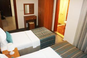 Habitación de hotel con 2 camas y espejo en My Rezidance Hotel, en Manisa