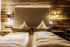 two beds with pillows in a room with wooden walls at Chalets - The Peak in Sölden