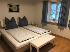 1 dormitorio con 2 camas, ventana y banco en Haus-Dorfstrasse en Risum-Lindholm