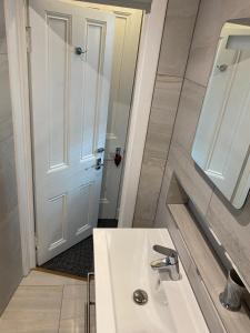La salle de bains est pourvue d'un lavabo blanc et d'un miroir. dans l'établissement SAKAN, à Peebles
