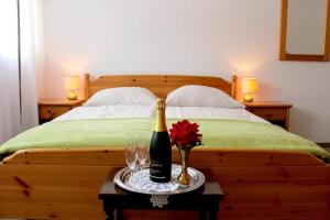 Hotel Gasthaus Zur Linde في غلوترال: غرفة نوم بسرير مع زجاجة من الشمبانيا والاكواب