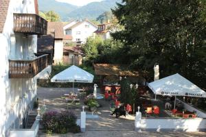 eine Außenterrasse mit Sonnenschirmen, Stühlen und Tischen in der Unterkunft Hotel Gasthaus Zur Linde in Glottertal