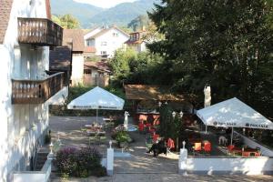 un patio esterno con ombrelloni, sedie e tavoli di Hotel Gasthaus Zur Linde a Glottertal