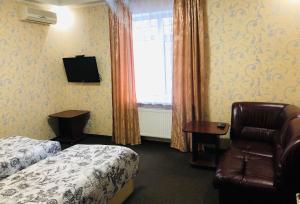 Hotel Т2 في كييف: غرفه فندقيه بسرير وكرسي ونافذه