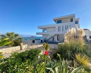 una casa en la playa con plantas en primer plano en Luxury BEACH VILLA VIR / apartments, en Vir