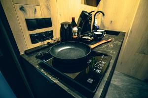 a pan on top of a stove in a kitchen at ÖÖD Hötels Rooslepa - Room#1-ÄLSKAR -with sauna in Rooslepa