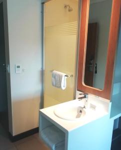a bathroom with a sink and a mirror and a shower at SUN1 ALBERTON in Johannesburg