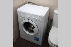 une machine à laver dans une salle de bain à côté des toilettes dans l'établissement Fiesta Apartment Seaview, à Mellieħa