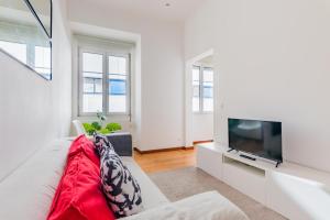 ein Wohnzimmer mit einem Sofa und einem Flachbild-TV in der Unterkunft LX Urban Living in Lissabon