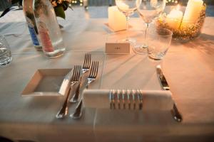 a table with forks and knives and wine glasses at Villa Curina Resort in Castelnuovo Berardenga +144 photos