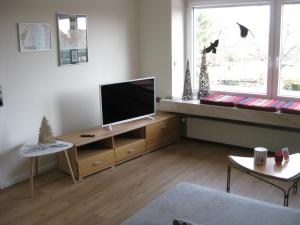ein Wohnzimmer mit einem Flachbild-TV auf einem Holzständer in der Unterkunft Bella Colonia Vieren in Hürth