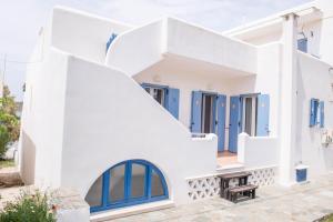 a white house with blue doors and stairs at Exohiko in Aliki