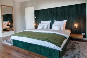um quarto com uma cama grande e uma cabeceira verde em Willa pod Lanckoroną em Izdebnik