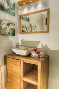 W łazience znajduje się umywalka i lustro. w obiekcie Côté Plage w mieście Saint-François