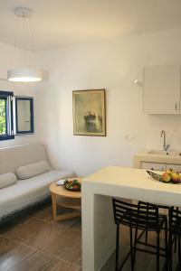 a kitchen and living room with a couch and a table at Kallichoron Country Houses in Astypalaia Town