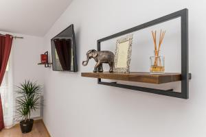 a mirror on a shelf with a statue of an elephant at Studio Roberta Coressi in Braşov
