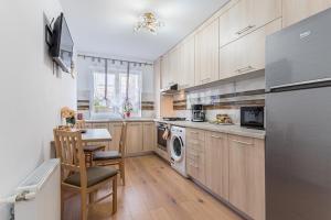 a kitchen with wooden cabinets and a table and a dishwasher at Studio Roberta Coressi in Braşov