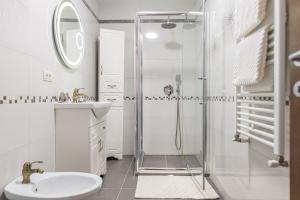 a white bathroom with a shower and a sink at Studio Roberta Coressi in Braşov +19 photos