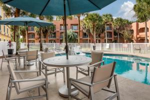 a patio with a table and chairs and a pool at Holiday Inn Express Hotel & Suites - The Villages, an IHG Hotel in The Villages