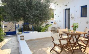 a patio with a table and chairs and a fence at Kallichoron Country Houses in Astypalaia Town