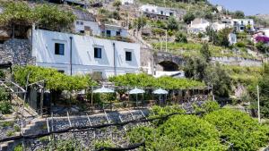 un edificio en una colina con árboles y sombrillas en B&B Ercole di Amalfi, en Amalfi