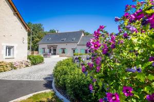 une maison avec des fleurs violettes en face d'une allée dans l'établissement Métairie du Villiers, à Saint-Branchs