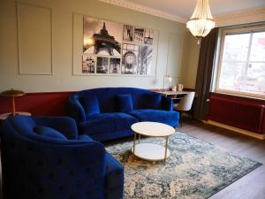 a living room with a blue couch and a table at Hotell Arkad in Västerås