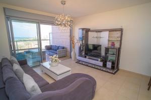 a living room with a couch and a tv and a mirror at Luxury Marina Beachfront by Airsuite in Ashdod