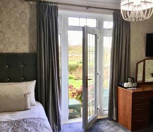 a bedroom with a bed and a sliding glass door at Westlea Guest House in Alnmouth