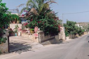 a street with a fence with plants and flowers at Eleftherias Suites - Near Beach Apartments in Marathi